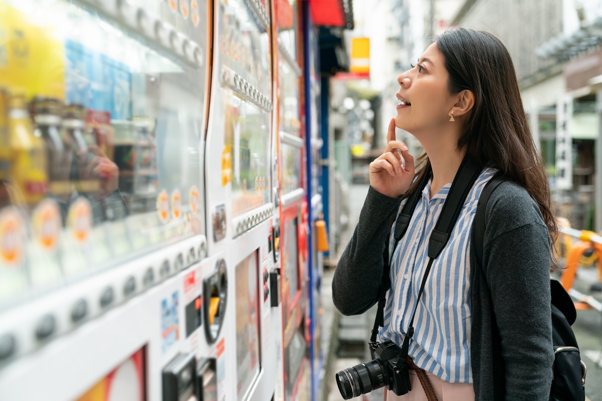 woman thinking which to buy from vending machine